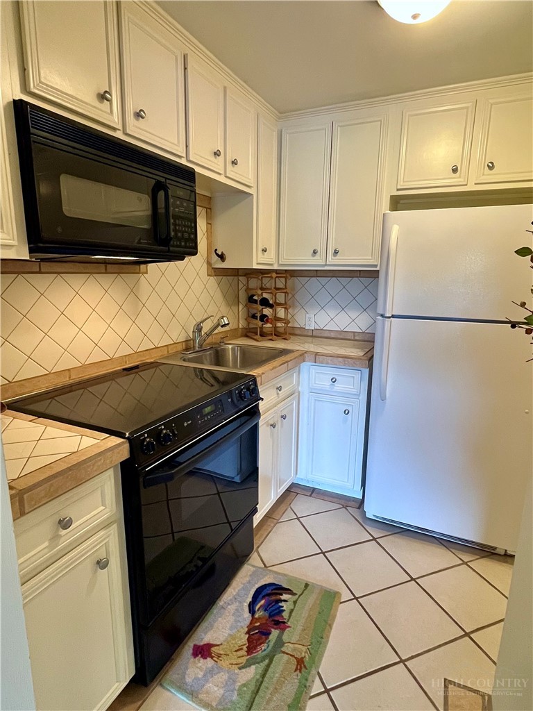 638 Ridge Road Glade Valley, NC 28627 - Photo 24 of 44 a kitchen with granite countertop white cabinets and white appliances