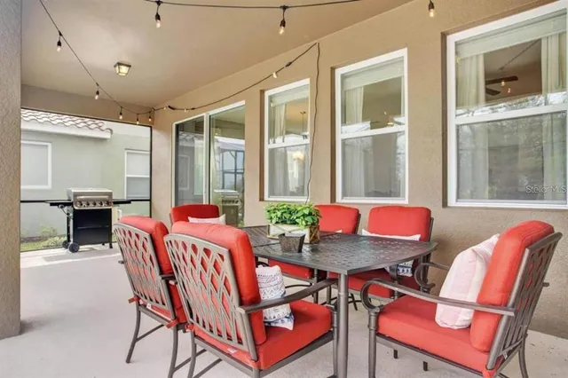 a dining room with furniture and a floor to ceiling window