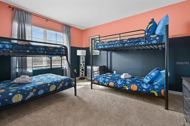 a large bed sitting in a bedroom next to a window