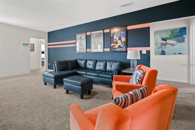 a living room with furniture a rug and a painting on the wall