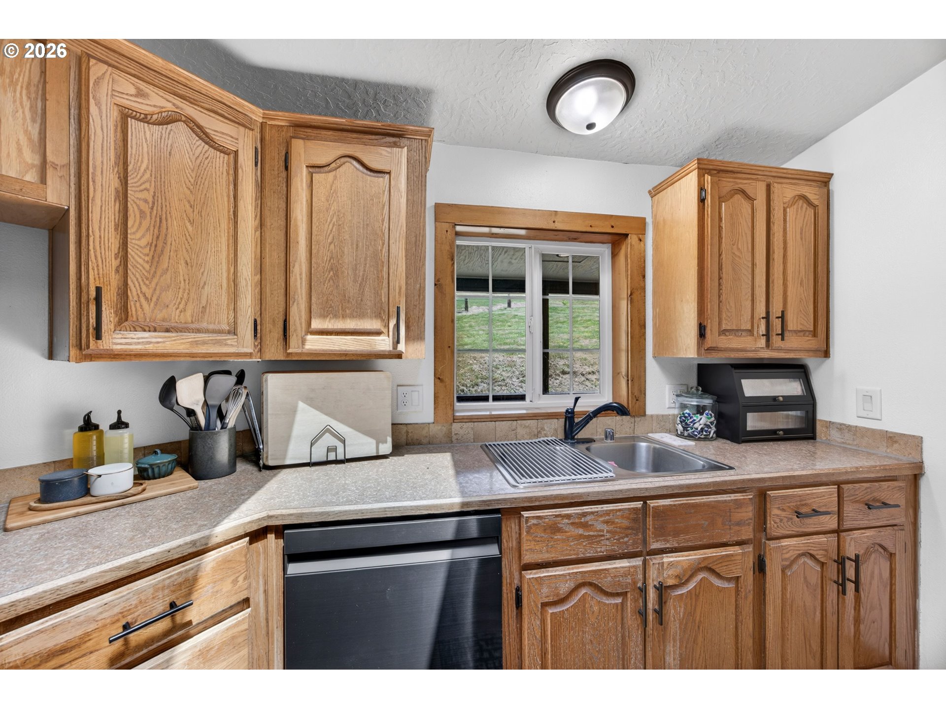 6895 Canary Road Westlake, OR 97493 - Photo 8 of 40 a kitchen with stainless steel appliances granite countertop white cabinets and a granite counter tops with a large window
