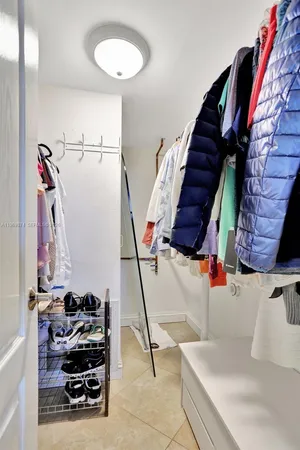a view of walk in closet with clothes and shoes