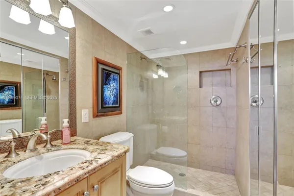 a bathroom with a granite countertop sink toilet and shower