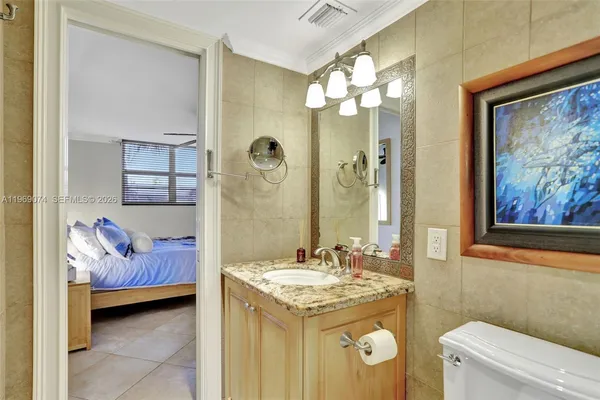 a en suite bathroom with a granite countertop sink and a mirror
