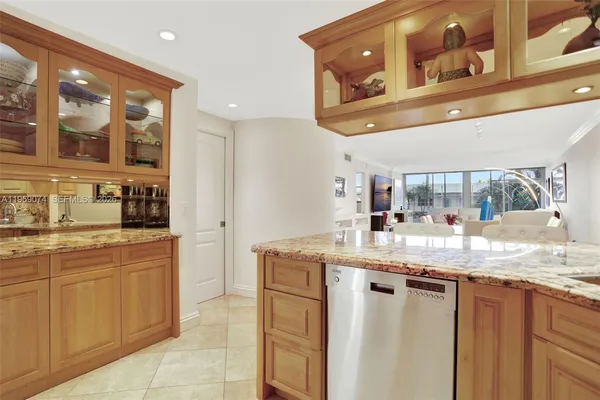 a kitchen with stainless steel appliances granite countertop a sink and dishwasher a stove with wooden cabinets
