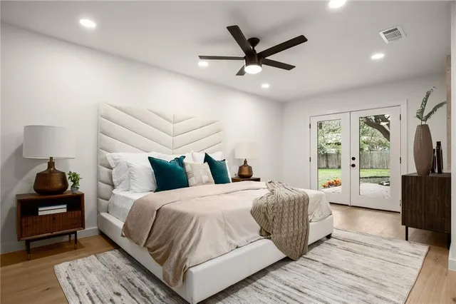a bedroom with a large bed a chandelier and a window