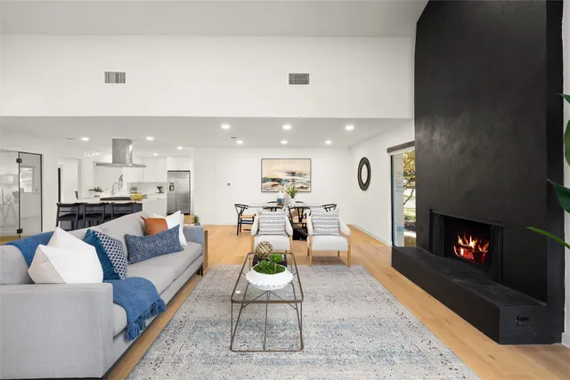 a living room with furniture and a fireplace with wooden floor