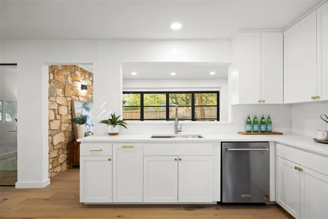 a kitchen with a sink window and cabinets