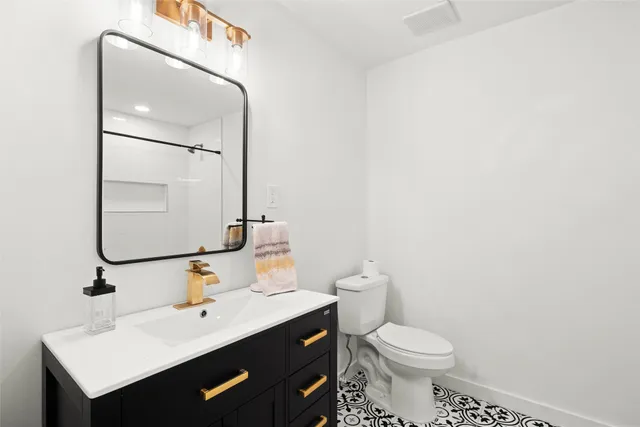 a bathroom with a sink mirror and toilet