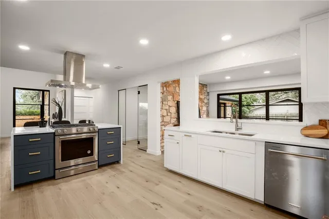 a kitchen with stainless steel appliances granite countertop a stove and a sink