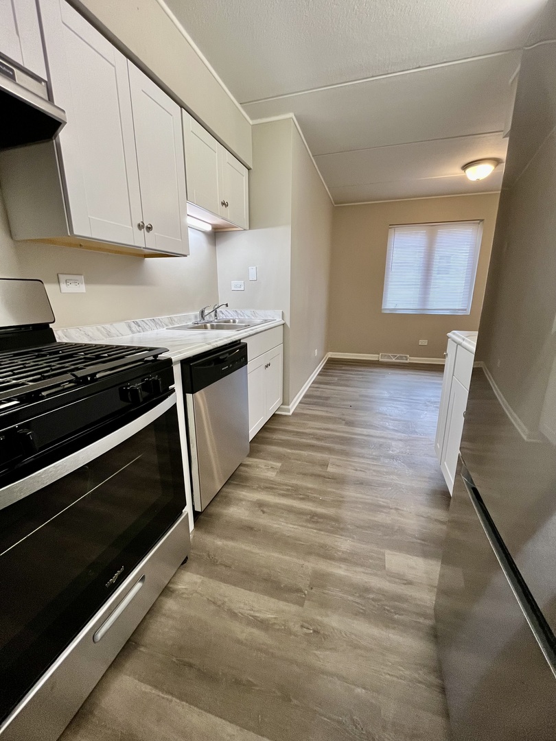 914 School Street, Unit 1 Lisle, IL 60532 - Photo 2 of 8 a kitchen with granite countertop stove and cabinets