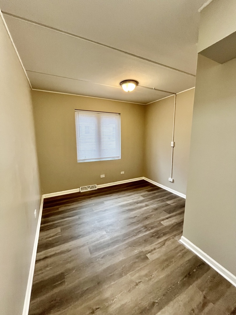 914 School Street, Unit 1 Lisle, IL 60532 - Photo 3 of 8 an empty room with wooden floor and windows