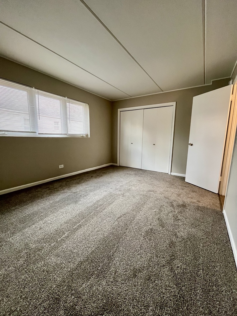 914 School Street, Unit 1 Lisle, IL 60532 - Photo 8 of 8 a view of an empty room with wooden floor and windows