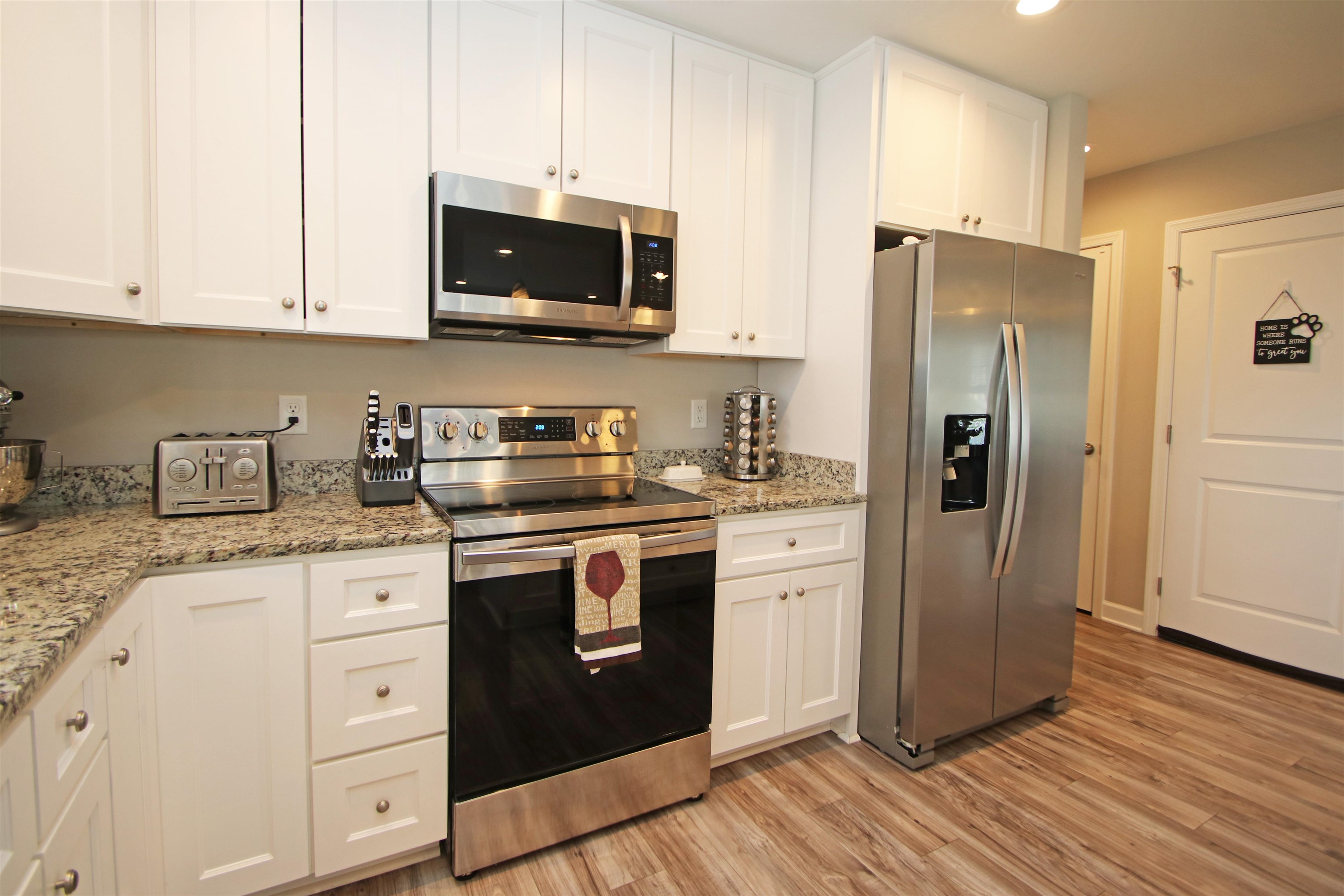 224 Spring Run Lane Waynesboro, VA 22980 - Photo 16 of 52 a kitchen with stainless steel appliances granite countertop a refrigerator stove and white cabinets with wooden floors