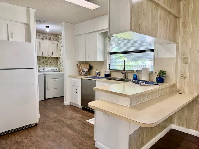 a kitchen with white cabinets and white appliances