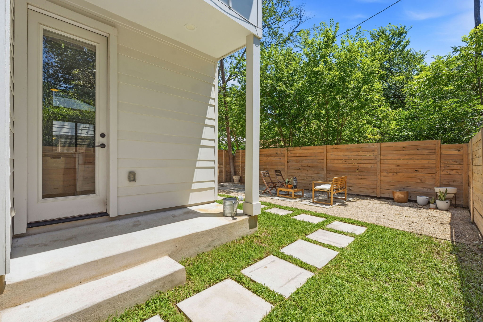 2935 Moss Street, Unit 2 Austin, TX 78722 - Photo 19 of 20 A private, fenced outdoor space with stepping stones leading to a seating area.