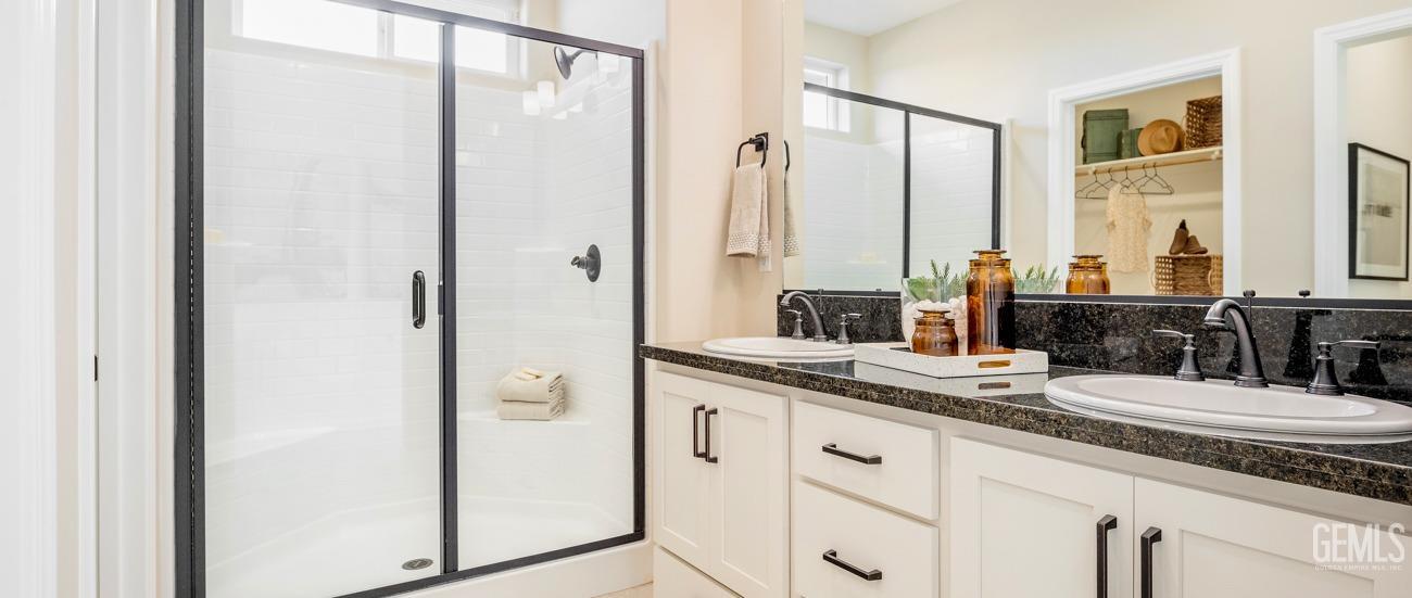 Undisclosed Address Bakersfield, CA 93314 - Photo 11 of 16 a bathroom with a double vanity sink and mirror with shower