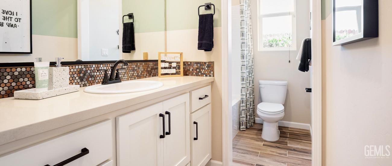 Undisclosed Address Bakersfield, CA 93314 - Photo 13 of 16 a bathroom with a granite countertop sink a toilet and a mirror