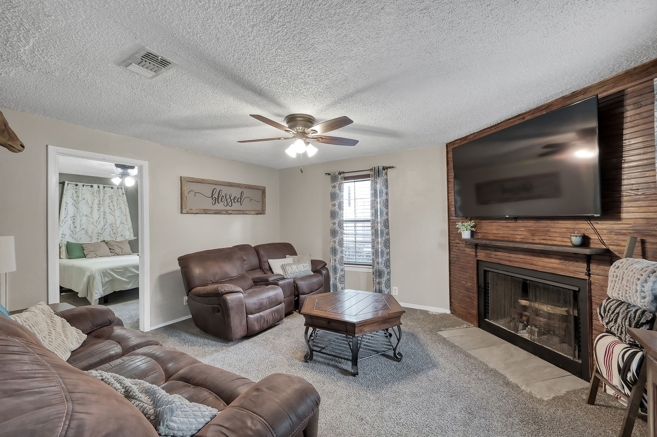 24193 Parker Road Porter, TX 77365 - Photo 10 of 15 a living room with furniture a flat screen tv and a fireplace
