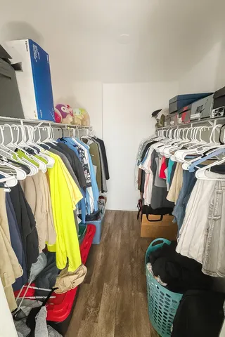 a view of walk in closet with clothes and shoes