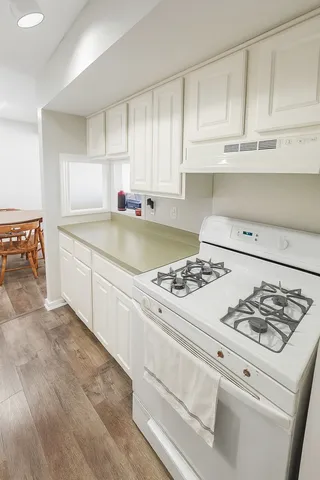 a kitchen with white cabinets and appliances