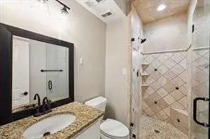 a bathroom with a granite countertop sink toilet and shower