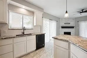 a kitchen with granite countertop cabinets stainless steel appliances a sink and a window