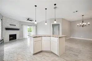 a view of a kitchen with a sink a fireplace and window
