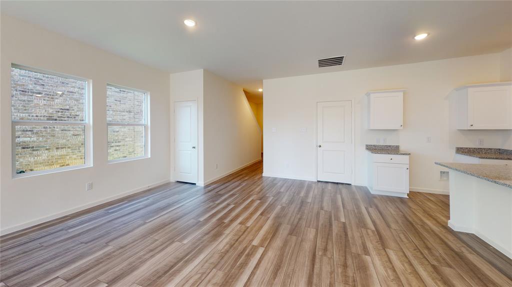 1706 Washington Street Princeton, TX 75407 - Photo 2 of 19 an empty room with wooden floor and windows