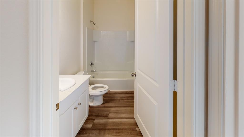 1706 Washington Street Princeton, TX 75407 - Photo 7 of 19 a bathroom with a granite countertop sink a toilet and a bathtub