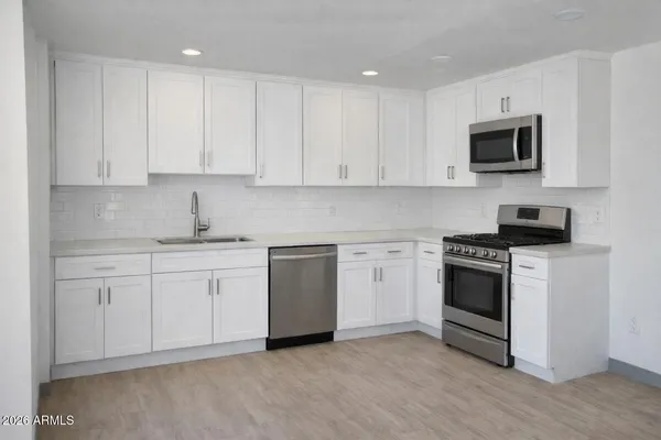 a kitchen with stainless steel appliances granite countertop a stove a sink and a microwave