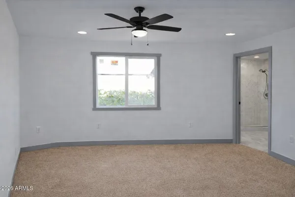 an empty room with a window and a fan