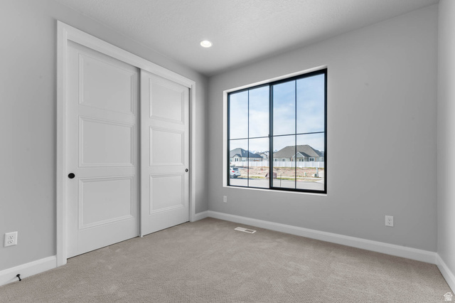11673 South Halls Crk Road Draper, UT 84020 - Photo 15 of 22 Room featuring light gray walls, plush carpeting, and a large window with black grilles