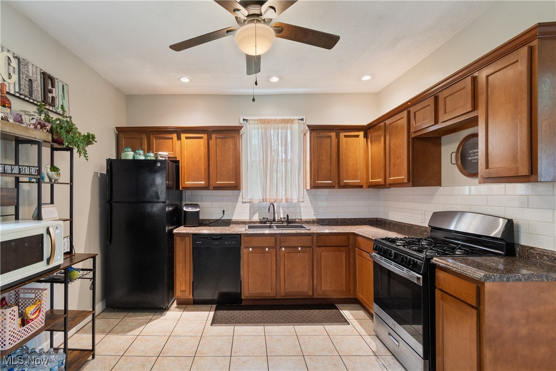 3609 Mahoning Road Northeast Canton, OH 44705 - Photo 7 of 31 Kitchen with black appliances, brown cabinetry, tasteful backsplash, light tile patterned flooring, and recessed lighting
