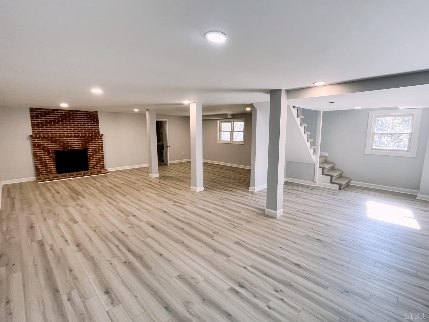 288 Lynbrook Road Rustburg, VA 24588 - Photo 18 of 34 an empty room with wooden floor fireplace and windows