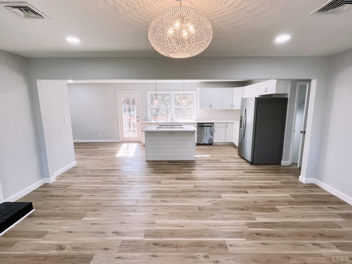 288 Lynbrook Road Rustburg, VA 24588 - Photo 2 of 34 a view of kitchen and empty room with wooden floor