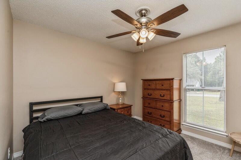 422 John King Road Crestview, FL 32539 - Photo 15 of 30 a bedroom with a bed and a chandelier