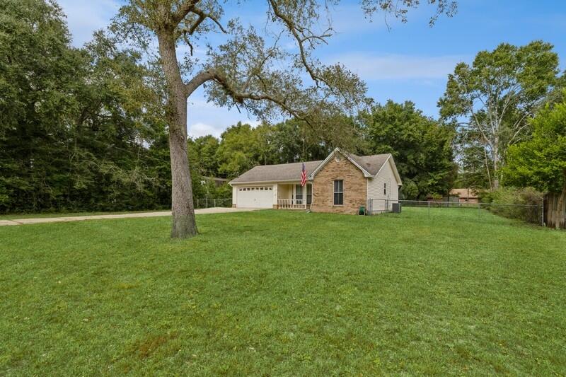 422 John King Road Crestview, FL 32539 - Photo 2 of 30 a view of a white house in front of a big yard with large trees