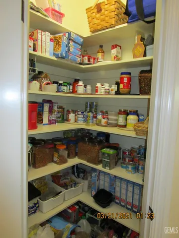 a room with stainless steel appliances a shelf and a book shelf