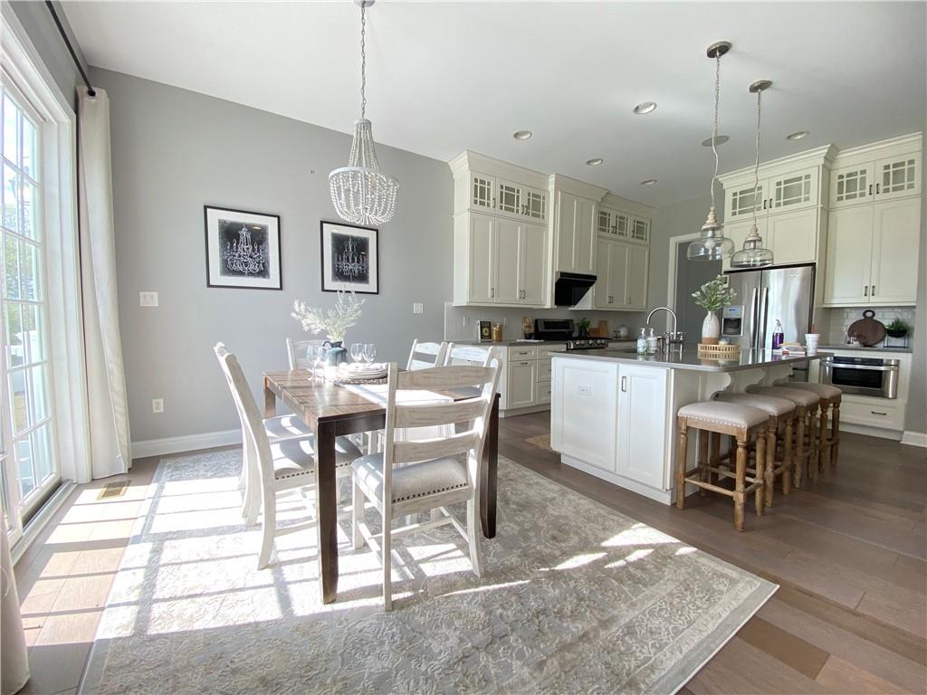 239 Venango Trail Mars, PA 16046 - Photo 15 of 39 a dining hall with stainless steel appliances granite countertop a stove a sink a dining table and chairs with wooden floor