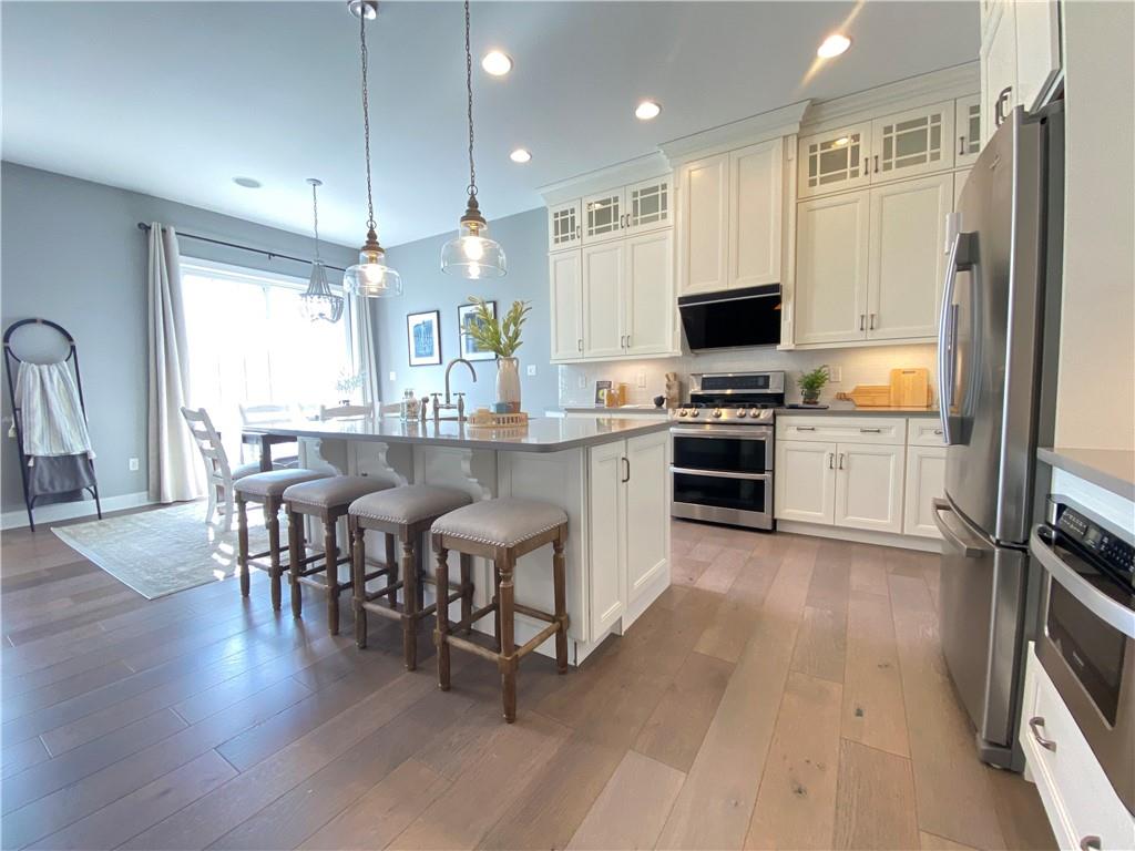 239 Venango Trail Mars, PA 16046 - Photo 9 of 39 a kitchen with kitchen island granite countertop wooden floors and stainless steel appliances