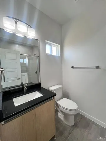 a bathroom with a sink a toilet a mirror and shower