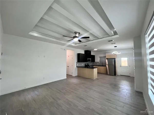 a view of kitchen with microwave refrigerator and cabinets
