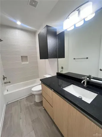 a bathroom with a granite countertop sink and a large mirror