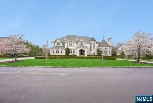 a view of a house with a big yard and large trees