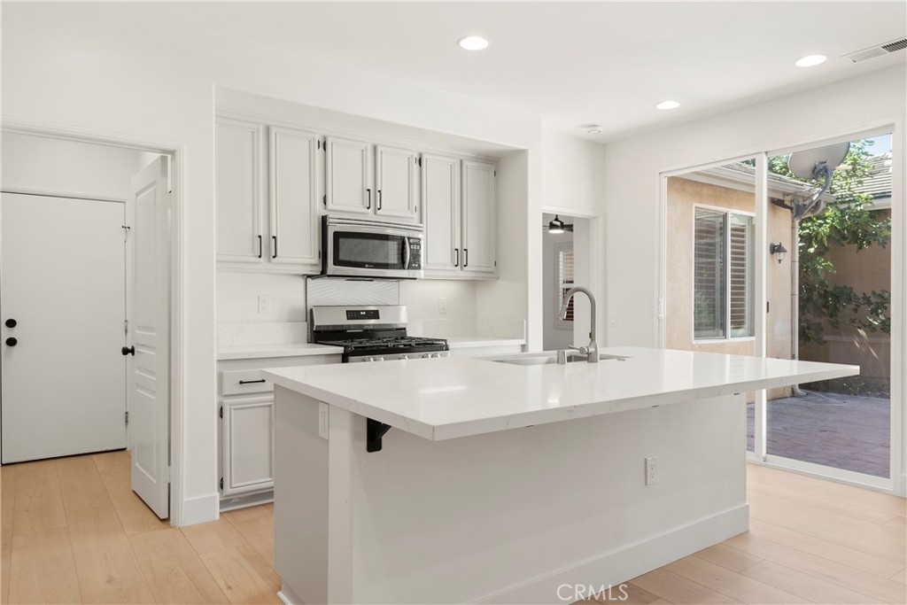 256 4 Seasons Boulevard Hemet, CA 92545 - Photo 9 of 31 a kitchen with kitchen island a sink appliances and cabinets