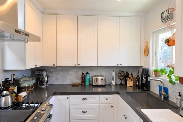 a kitchen with a white stove top oven and cabinets
