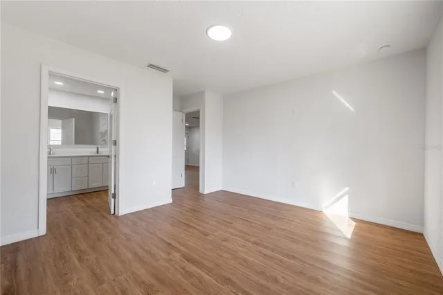 a view of a room with wooden floor and a bathroom