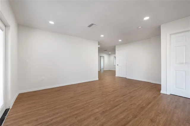 a view of an empty room with wooden floor