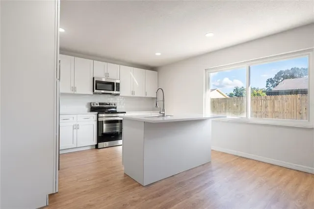 a kitchen with granite countertop white cabinets and appliances